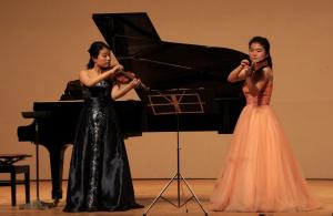バイオリンを指ではじく演奏を魅せる長尾春花さんと小林沙紀さん