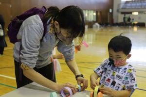 紙飛行機を作る親子連れ