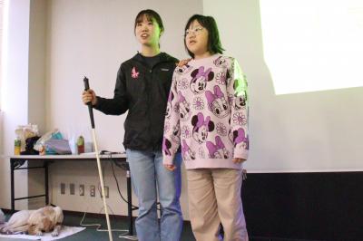 白杖を持った人を案内する参加者