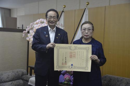 受章の賞状を掲げる大場玲子さんと市長