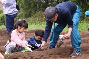 植え付け作業をする親子